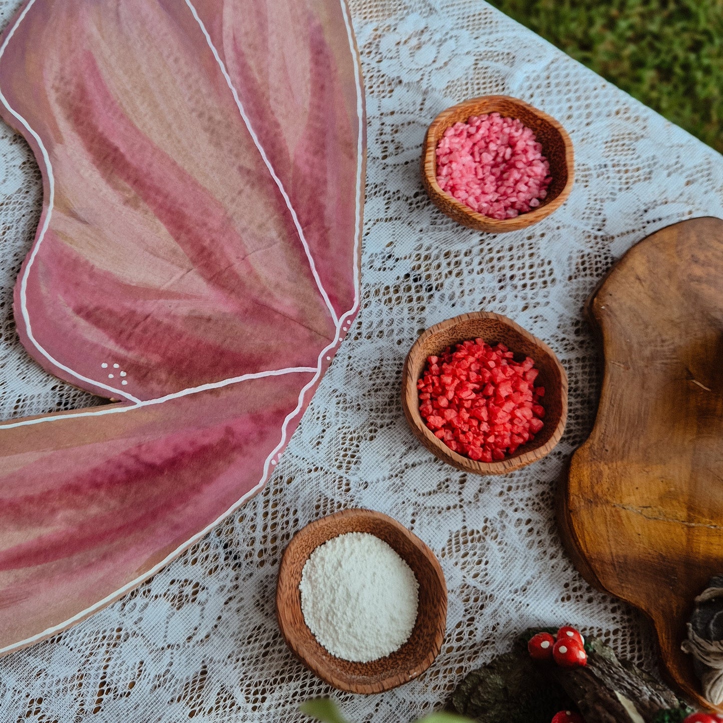 Pink butterfly wings with small bowls of red & pink Barefoot potions shimmer rocks